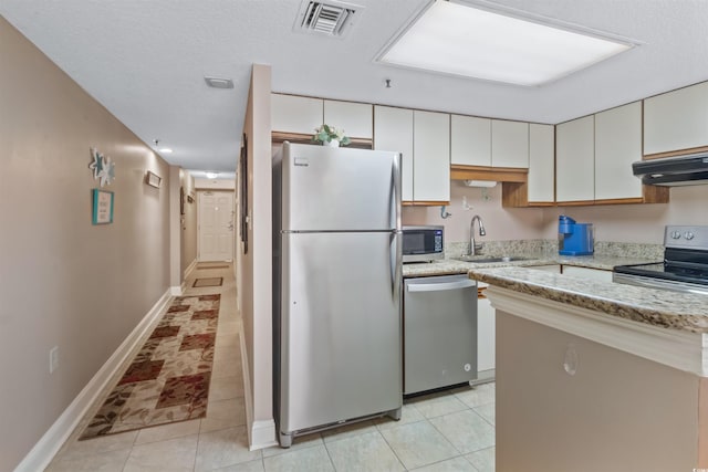 kitchen featuring visible vents, under cabinet range hood, stainless steel appliances, white cabinetry, and a sink