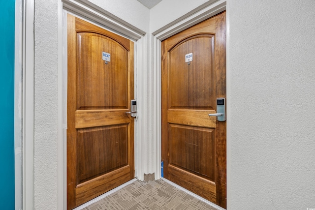 doorway to outside featuring a textured wall