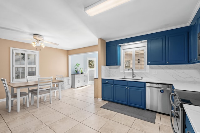 kitchen featuring stainless steel appliances, light countertops, a sink, and blue cabinetry