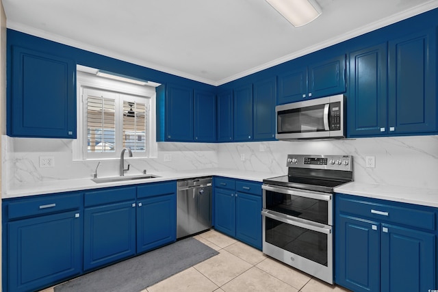 kitchen featuring appliances with stainless steel finishes, light countertops, a sink, and decorative backsplash