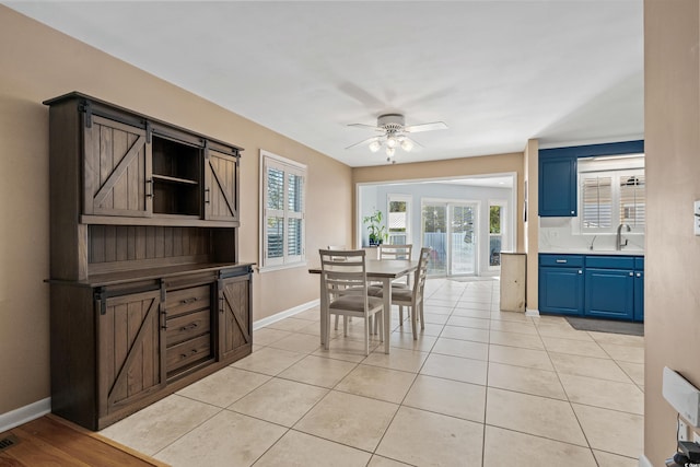 dining room featuring a ceiling fan, light tile patterned flooring, and baseboards