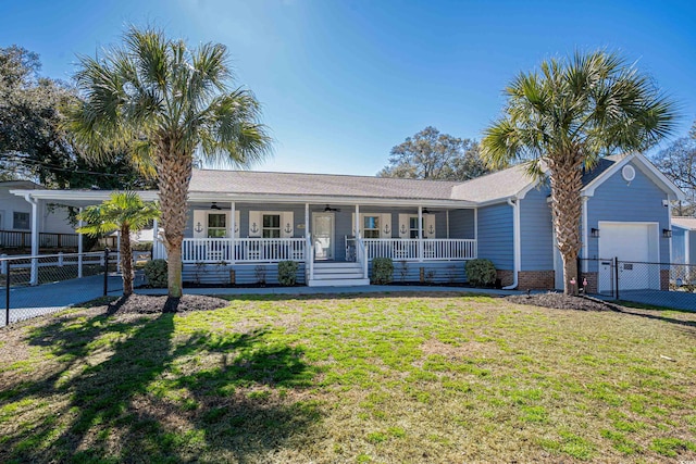 ranch-style house with fence, a front yard, covered porch, a garage, and a ceiling fan