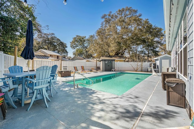 view of pool with a storage shed, an outdoor structure, and a fenced in pool