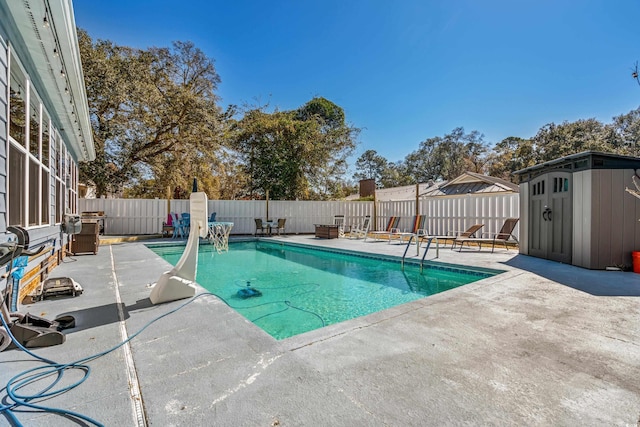 view of swimming pool with a fenced in pool, a storage unit, a patio area, a fenced backyard, and an outdoor structure