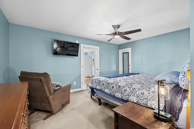 bedroom with a ceiling fan, light carpet, ensuite bath, and baseboards