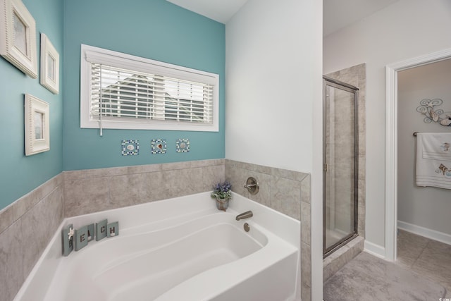 bathroom with a stall shower and a garden tub