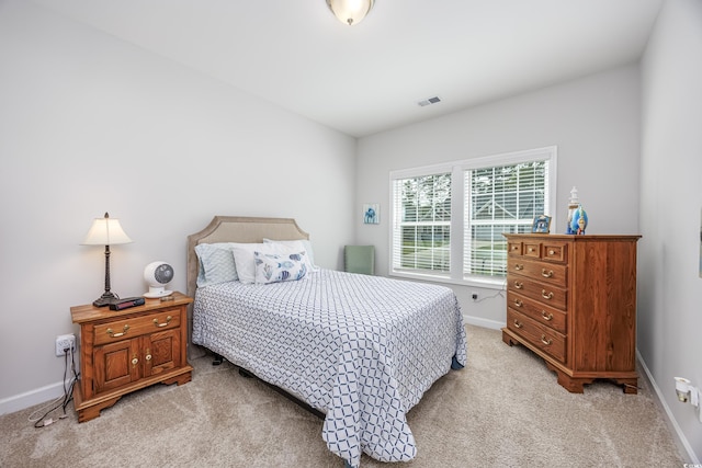 bedroom featuring light carpet, visible vents, and baseboards