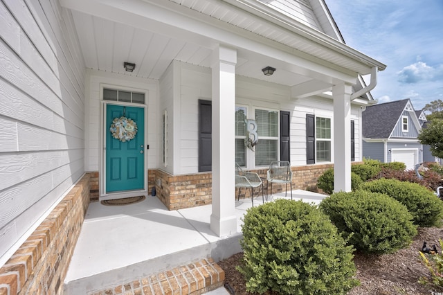 property entrance with covered porch and brick siding