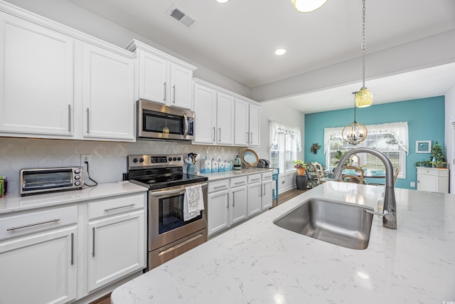 kitchen with visible vents, stainless steel appliances, and white cabinetry