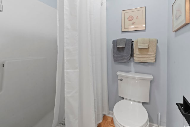 bathroom with a shower with shower curtain and toilet