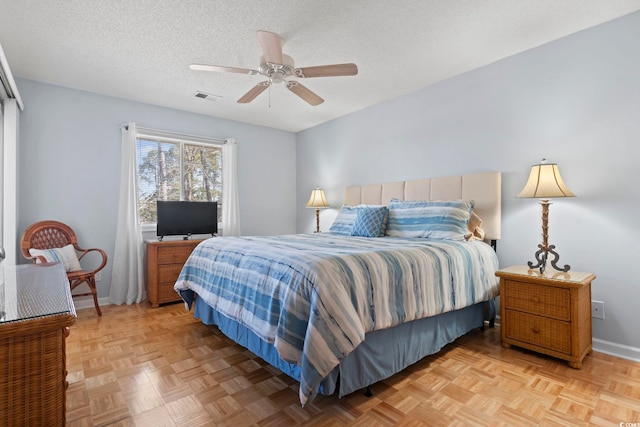 bedroom with a textured ceiling, a ceiling fan, visible vents, and baseboards