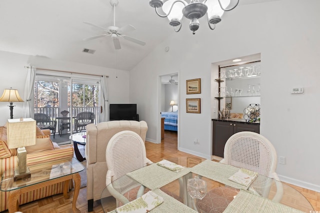 dining space with high vaulted ceiling, visible vents, baseboards, and ceiling fan with notable chandelier