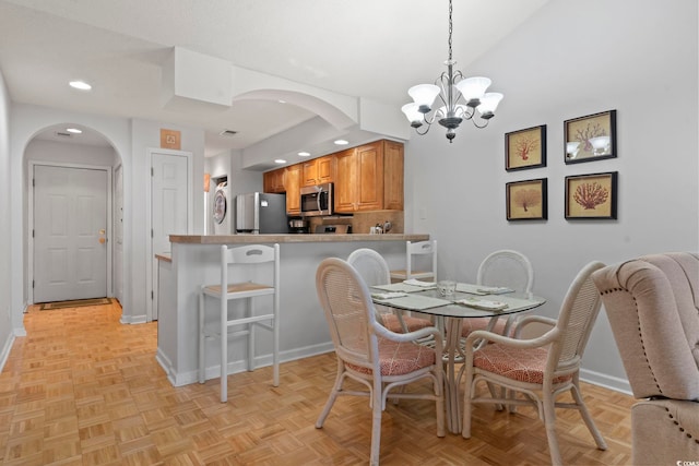 dining room with baseboards, arched walkways, a notable chandelier, and recessed lighting