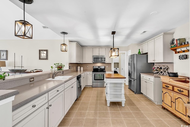 kitchen featuring stainless steel appliances, butcher block countertops, decorative light fixtures, and white cabinets