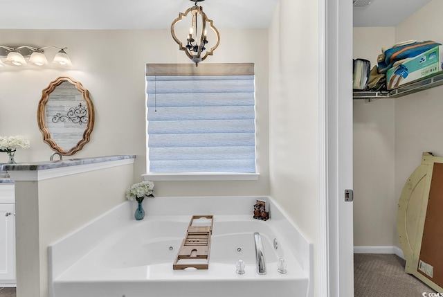 full bath with a whirlpool tub and an inviting chandelier