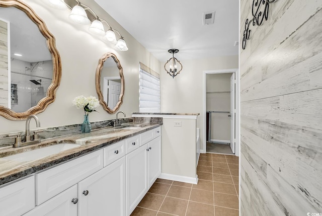 bathroom with double vanity, tile patterned flooring, visible vents, and a sink