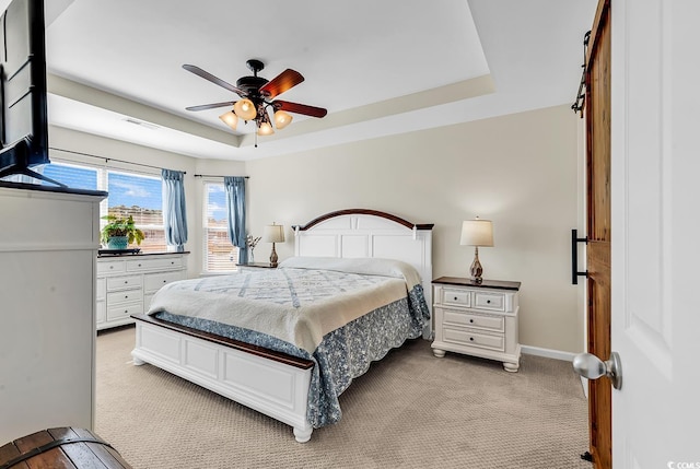 bedroom featuring a raised ceiling, light carpet, visible vents, and baseboards