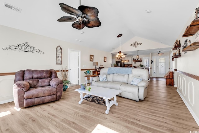 living area with light wood-style floors, visible vents, vaulted ceiling, and ceiling fan with notable chandelier