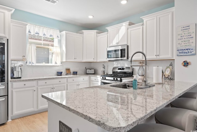 2476 Blue Crane Cir Unit 101, Myrtle Beach, SC 29577 - kitchen featuring a peninsula, appliances with stainless steel finishes, and white cabinetry