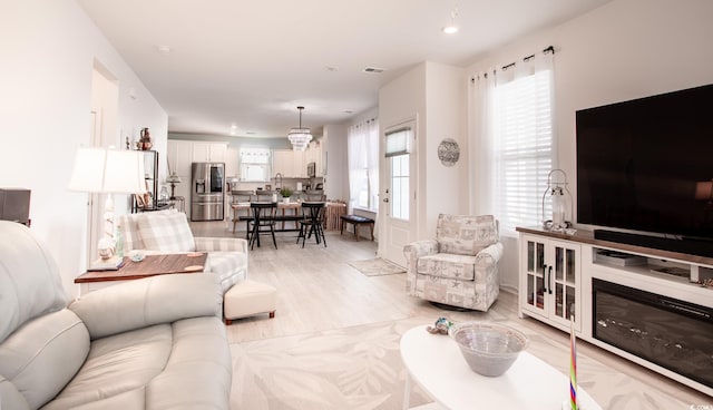 living area featuring light wood-type flooring, visible vents, and recessed lighting