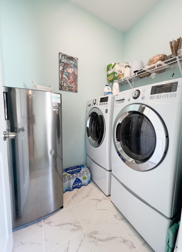 laundry room with marble finish floor, washer and clothes dryer, and laundry area