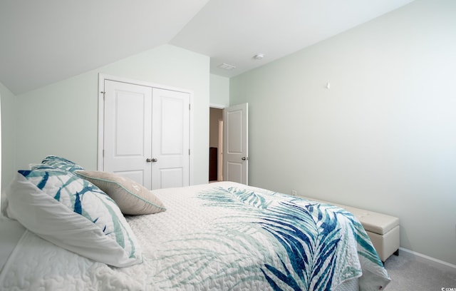 carpeted bedroom featuring a closet, vaulted ceiling, and baseboards