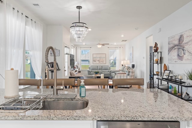 2476 Blue Crane Cir Unit 101, Myrtle Beach, SC 29577 - kitchen featuring a sink, open floor plan, visible vents, ceiling fan with notable chandelier, and light stone countertops