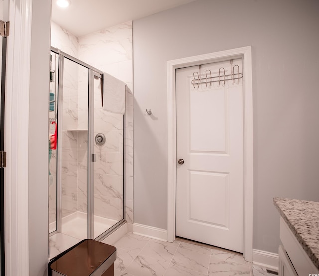 bathroom featuring a marble finish shower, marble finish floor, and baseboards