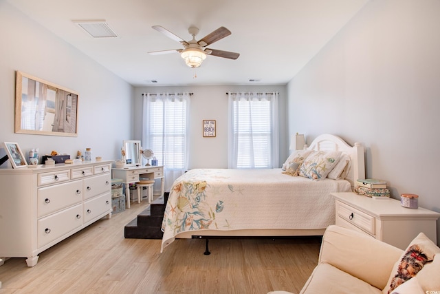 bedroom with ceiling fan, light wood finished floors, and visible vents