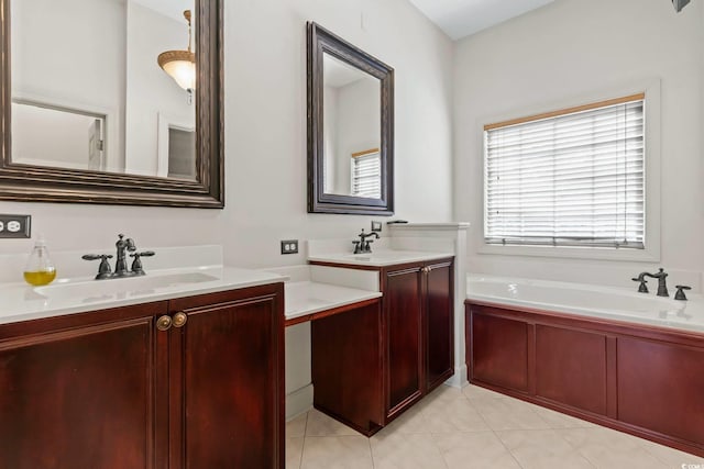 full bathroom featuring a sink, two vanities, a garden tub, and tile patterned floors