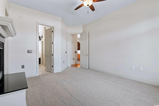 unfurnished bedroom featuring ceiling fan, baseboards, and light colored carpet