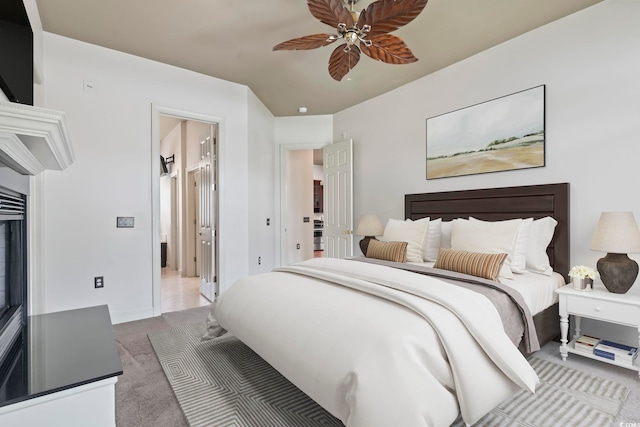 carpeted bedroom with ensuite bathroom and ceiling fan