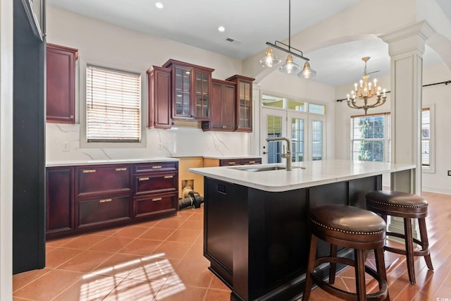 kitchen with pendant lighting, an inviting chandelier, visible vents, a sink, and ornate columns
