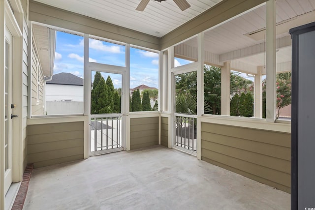 unfurnished sunroom featuring a ceiling fan