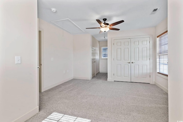 unfurnished bedroom featuring baseboards, attic access, and carpet floors