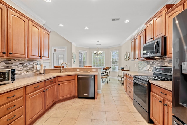 kitchen featuring light tile patterned floors, appliances with stainless steel finishes, a peninsula, crown molding, and a sink