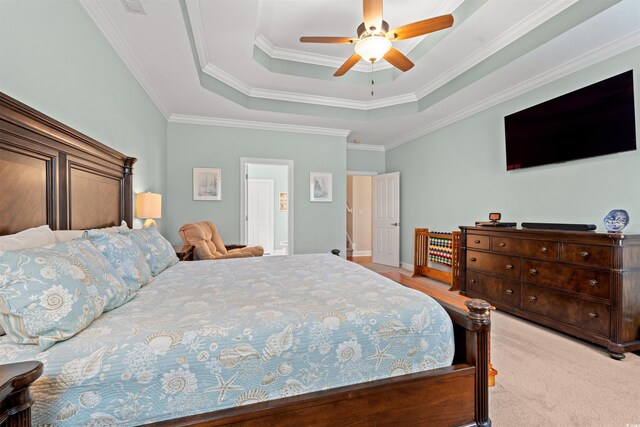 carpeted bedroom featuring a ceiling fan, a tray ceiling, and crown molding