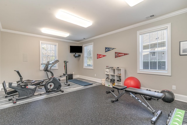 exercise area featuring baseboards and crown molding