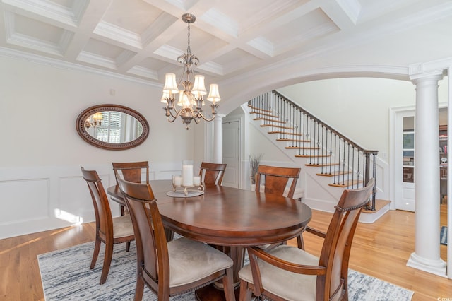 dining room featuring light wood-style floors, decorative columns, coffered ceiling, and beam ceiling