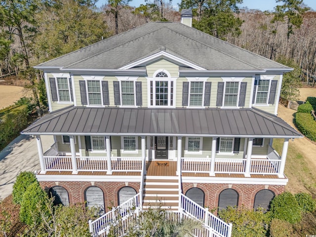 view of front of property with a balcony, a shingled roof, and stairway