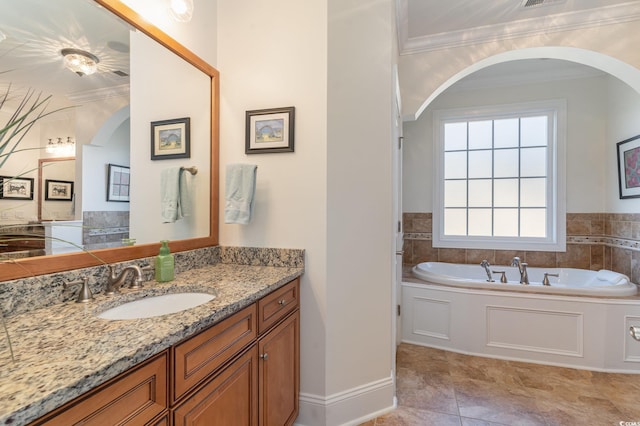 bathroom with visible vents, baseboards, vanity, a bath, and crown molding