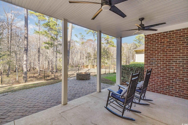 view of patio with ceiling fan, an outdoor fire pit, and fence