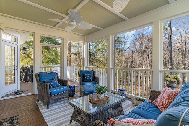 sunroom featuring beamed ceiling and a ceiling fan