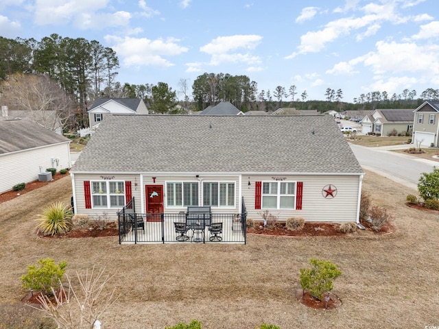 rear view of property with a shingled roof and a patio