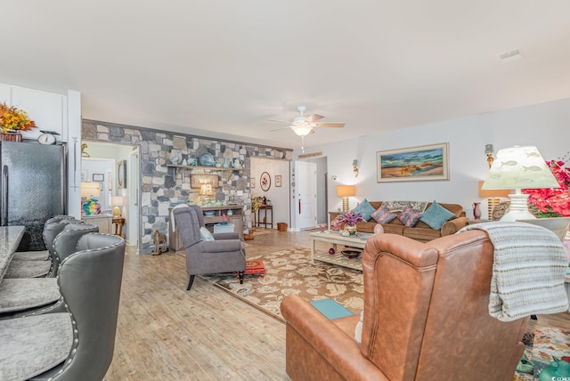 living area featuring light wood-style flooring and a ceiling fan