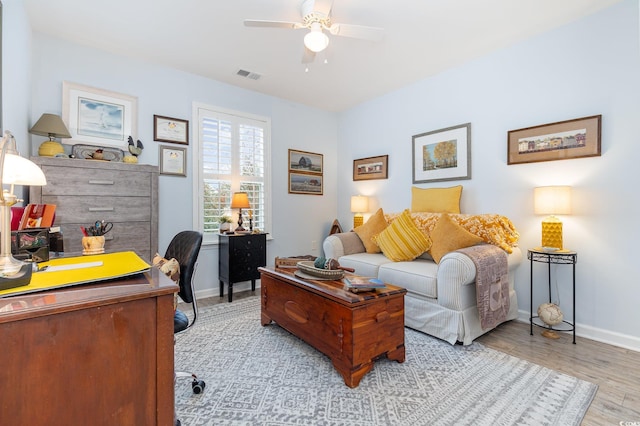 office featuring ceiling fan, wood finished floors, visible vents, and baseboards