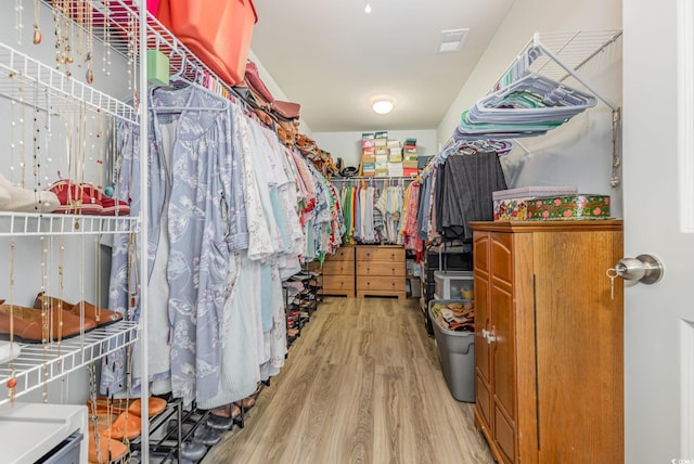 walk in closet with light wood-type flooring and visible vents