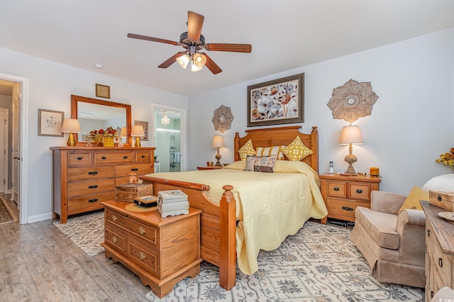 bedroom with light wood-style floors, ceiling fan, baseboards, and connected bathroom