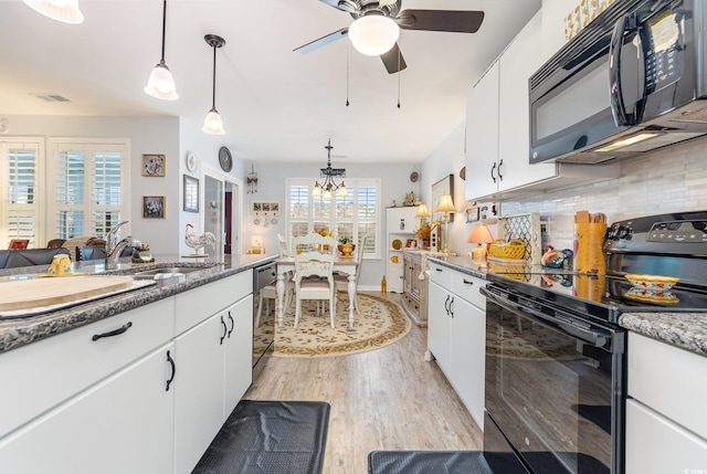 kitchen featuring black appliances, light wood-style flooring, and white cabinetry