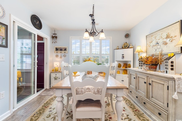 dining room featuring an inviting chandelier and light wood-style floors